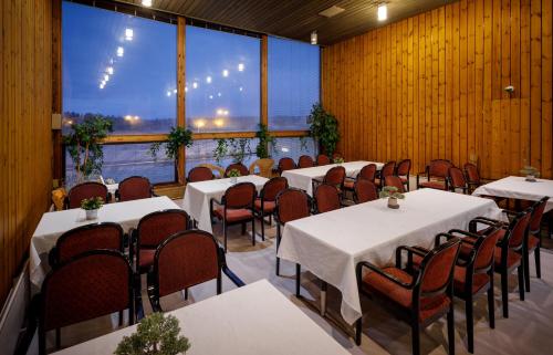 科特卡Hotelli Leikari的餐厅设有桌椅和大窗户。