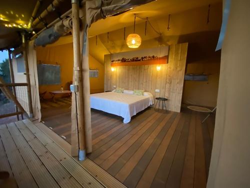TerradesGlamping VALL de CODÓ的一间卧室,在木甲板上配有一张床