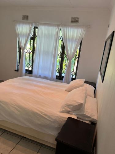 斯科特堡Mtunzi Park, 39 Peaceful shores的一间卧室配有一张带白色床单的床和一扇窗户。