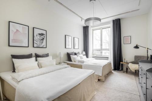 赫尔辛基Comfortable city home的白色卧室配有两张床和一张沙发