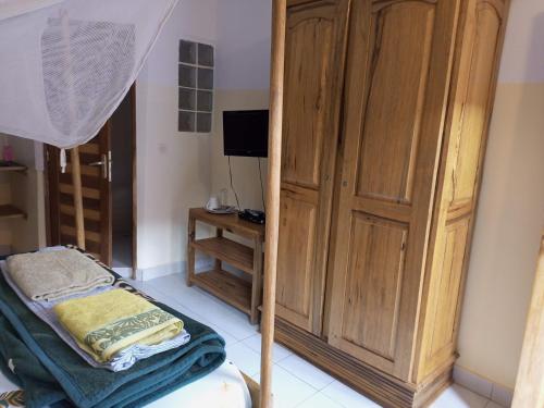 姆布尔Guesthouse Dalal ak Jàmm的一间卧室设有大型木制橱柜和一张床