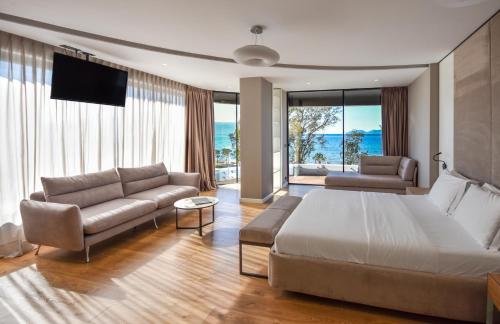 伏罗拉Yacht Hotel的一间卧室配有一张床、一张沙发和一台电视
