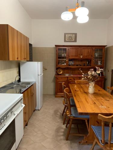 拉卡莱Casa Della Nonna的厨房配有木桌和白色冰箱。