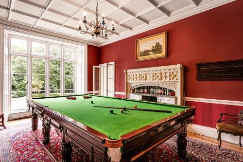 柯比朗斯代尔The Casterton Grange Estate的红色墙壁的房间里设有一张台球桌