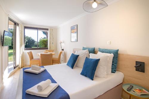 格里莫SOWELL Family Port Grimaud的卧室配有白色床和蓝色及白色枕头