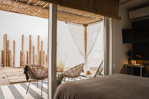 塞维利亚room Select Tetuán的一间带一张床和椅子的卧室,位于阳台