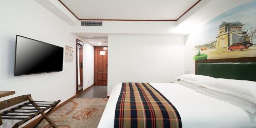 北京时光漫步怀旧主题酒店（北京天安门广场店）（原前门店）的一间卧室配有一张床和一台平面电视