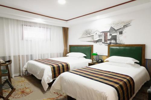北京时光漫步怀旧主题酒店（北京天安门广场店）（原前门店）的酒店客房设有两张床,墙上挂有绘画作品