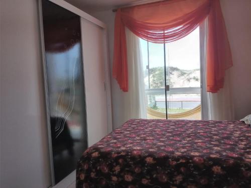 因贝Lindo Duplex à 50 metros da praia的一间卧室设有一张床和一个窗口