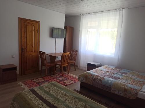 博斯特里米尔林姆罗科酒店的一间卧室设有两张床、一张桌子和一个窗口