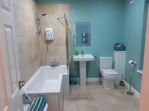 布莱克浦Blackpool Abode - Caxton Lodge的带浴缸、盥洗盆和卫生间的浴室