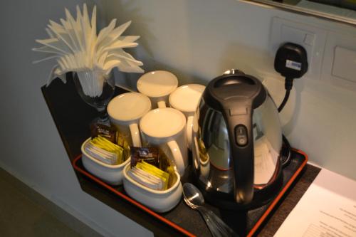 峇六拜DR槟城酒店 的茶壶和茶杯放在桌子上