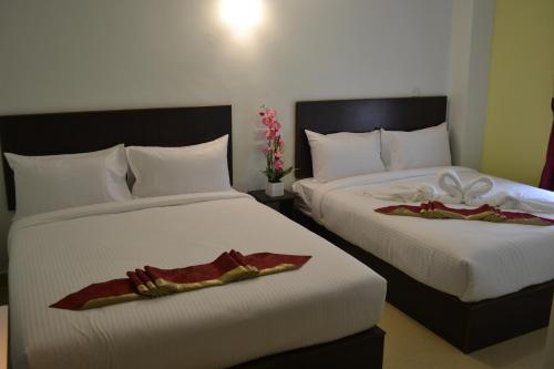 峇六拜DR槟城酒店 的两张位于酒店客房的床,配有毛巾
