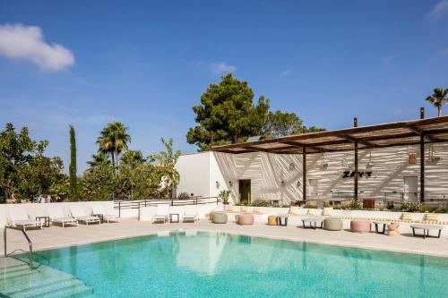 圣蓬萨Kimpton Aysla Mallorca, an IHG Hotel的一座带椅子的游泳池以及一座建筑