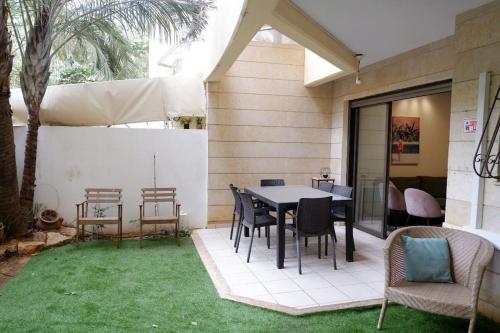 赖阿南纳Garden House By IsrApart的草地上带桌椅的天井