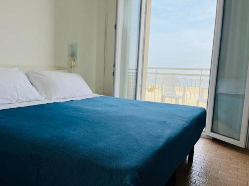 丽都迪萨维奥Hotel Lima的窗户客房内的一张带蓝色毯子的床