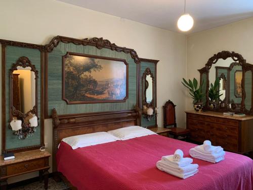 Pieve di TecoAlbergo Dell'Angelo的一间卧室配有一张带红色床罩和镜子的床