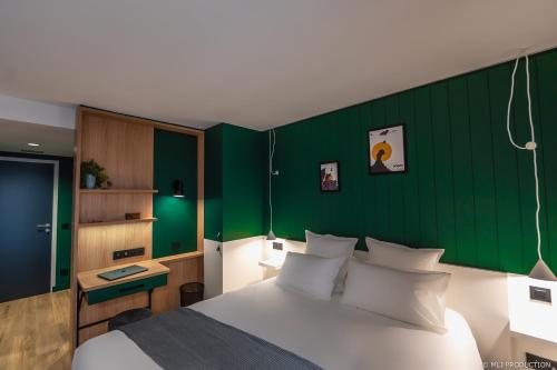 潘波勒Les Hauts de Kerano的卧室设有白色的床和绿色的墙壁
