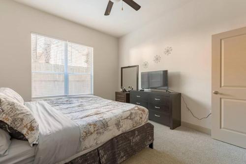 休斯顿Home felt apartment- Med Center/NRG的一间卧室设有一张床、一台电视和一个窗口。