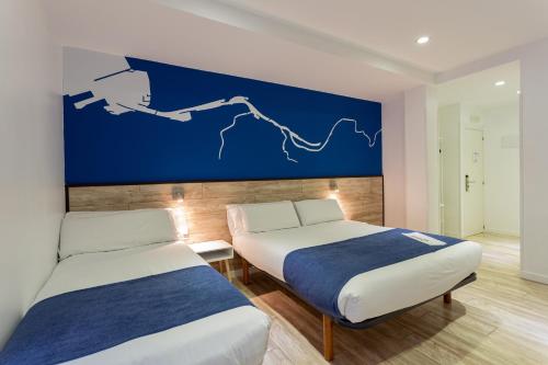 毕尔巴鄂Casual Blue的蓝色墙壁客房的两张床