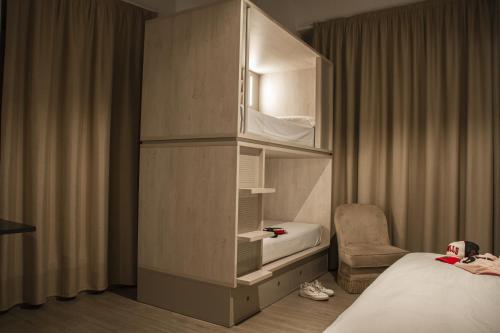 塞维利亚room00 Salvador Hostel的酒店客房设有一间带一张床和橱柜的卧室