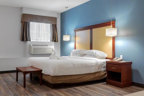 汉密尔顿Premier Inn & Suites - Downtown Hamilton的一间卧室配有一张大床和一部电话