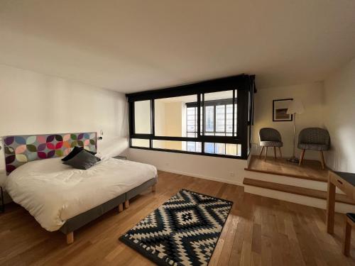 巴黎Hôtel Villa Blomet的一间卧室设有一张床和一个大窗户
