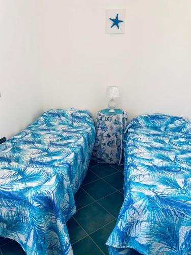 兰佩杜萨Villa Ale的两张睡床彼此相邻,位于一个房间里
