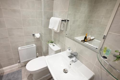 伯明翰Luxury 4 Bed House with Gated Parking in the Heart of Birmingham!的浴室配有白色卫生间和盥洗盆。