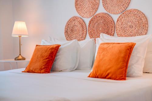 里斯本达维拉旅馆的白色的床,配有橙色和白色的枕头