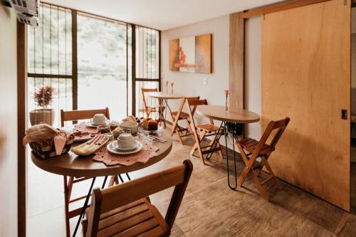 本图贡萨尔维斯CasAlta Pousada的一间带桌椅的用餐室和窗户。