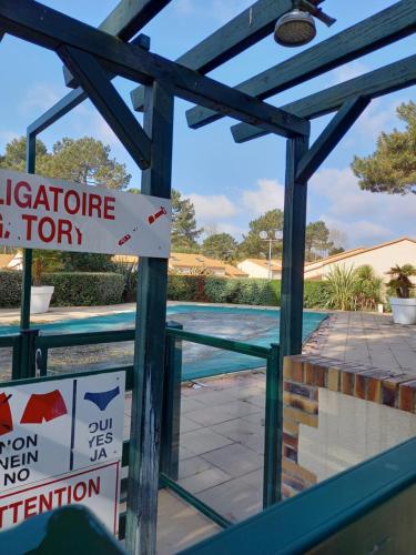 莱马特Talaris La Palmyre的游泳池,上面有标志,上面写着游泳合格的氯气健身房