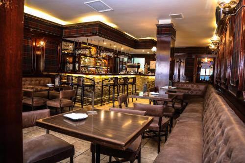 蓬塔阿雷纳斯HOTEL LOS NAVEGANTES的一间带桌椅的餐厅和一间酒吧