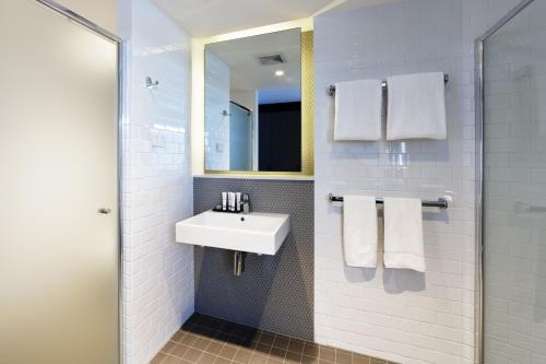 布里斯班布里斯班阿尔法马赛克佛特谷酒店的白色的浴室设有水槽和镜子