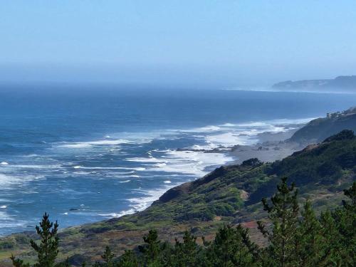 维丘肯Tinyhouse Boyeruca Lodge. Maravillosas vistas de Bosque, Mar y Cielo的从山顶上欣赏到海景