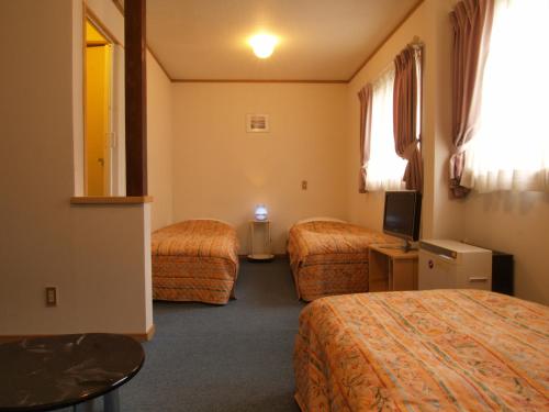 白马村彩虹山林小屋的酒店客房设有两张床和电视。