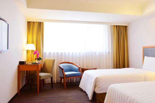 台南台南富华大饭店的酒店客房设有两张床、一张书桌和一个窗户。