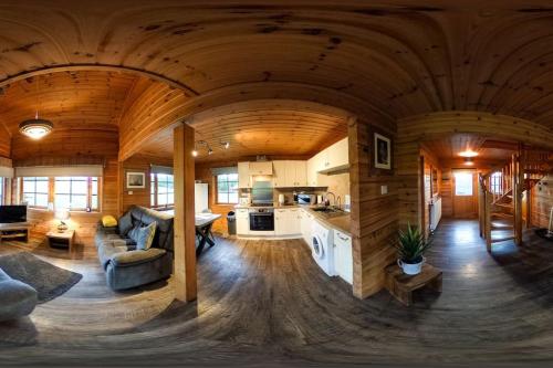 基斯Red Squirrel log cabin with hot tub的小木屋内的大型客厅和厨房