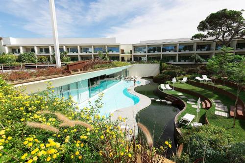 卡斯卡伊斯Onyria Marinha Boutique Hotel的一座带游泳池和度假村的大型建筑