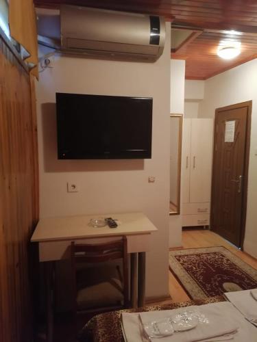 伊斯坦布尔Private Room in Istanbul #56的一间配有电视的墙上客房,配有一张桌子