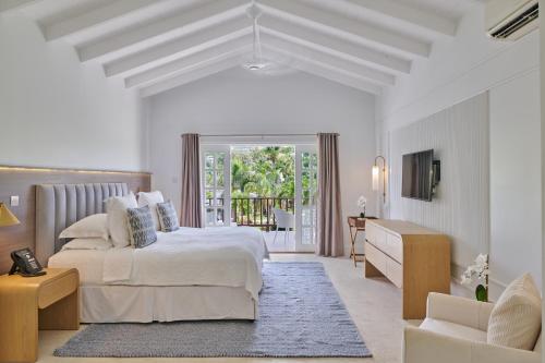 圣乔治Calabash Hotel的一间白色的卧室,配有床和客厅