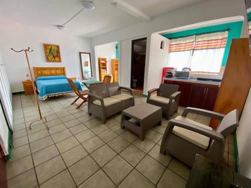 瓦哈卡市Hostal Mixteco Naba Nandoo的客厅配有沙发、一张床和椅子