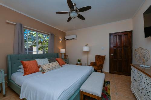 棕榈滩Villa Tamar的一间卧室配有一张床和吊扇