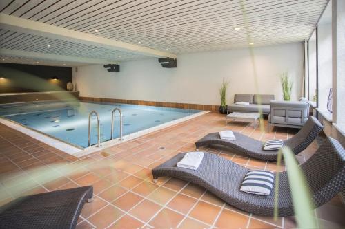 温特贝格Boutique-Hotel Weigels Bergfreiheit的一个带椅子的大型游泳池和一个游泳池