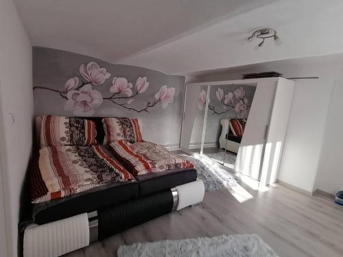 ČernoviceUbytování Dobešov的卧室配有一张挂着花壁画的床。