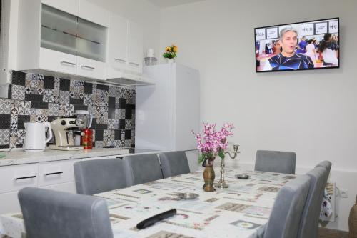 Novi KneževacVILA VASILIJE的厨房配有桌椅,墙上配有电视。