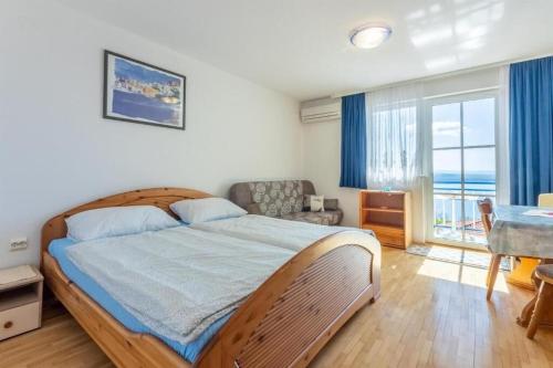 德拉马利Apartments Bozana的一间卧室配有一张床、一张桌子和一个窗户。