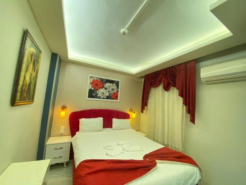 伊兹密尔ŞİRİNYER APART OTEL的一间卧室配有一张带红色床头板的大床