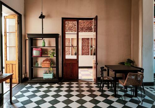查斯科穆斯La Botica de 1852 Hotel的一间设有桌子和棋盘地板的客房