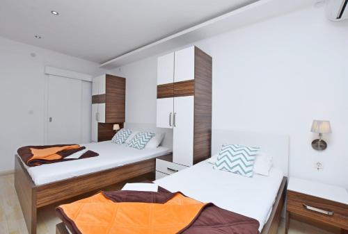 布德瓦Apartments Ivanovic的白色墙壁客房的两张床